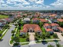 Extensive neighborhood view of home with red tile roof, lovely landscaping, and brick driveway at 15698 Panther Lake Dr, Winter Garden, FL 34787