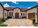 Luxurious home featuring a brick driveway leading up to a striking double door entrance at 15698 Panther Lake Dr, Winter Garden, FL 34787
