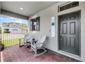 Inviting covered front porch with brick flooring and rocking chairs creating a relaxing outdoor space at 16484 Angel Fish Rd, Winter Garden, FL 34787