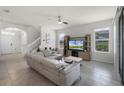 Open-concept living room with modern furniture, tile flooring, and ample natural light at 16484 Angel Fish Rd, Winter Garden, FL 34787