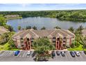 Stunning aerial view of a condo complex, lush landscaping, a lake, and ample parking at 1979 Summer Club Dr # 115, Oviedo, FL 32765