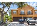 Two-story townhome with attached garage and balcony, featuring a tan stucco exterior at 2330 Little Gem Loop, Sanford, FL 32773