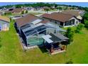 Aerial view of a backyard with a screened in pool, patio furniture, and lush green grass at 2376 Flamingo Lakes Dr, Kissimmee, FL 34743