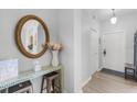 Inviting entryway featuring a decorative mirror, console table with flowers, and a view of the front door at 2706 Camaro Dr, Kissimmee, FL 34746