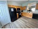 Functional kitchen with light wood cabinets, black appliances, and modern flooring at 2706 Camaro Dr, Kissimmee, FL 34746