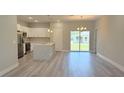 Bright, open-concept living area featuring a modern kitchen with white cabinets and stainless steel appliances at 2837 Sw 173Rd Street Rd, Ocala, FL 34473