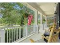 Inviting front porch with rocking chairs, American flag, and scenic neighborhood views at 3201 Glenmere Way, Orlando, FL 32828