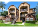 Inviting condo complex featuring multi-story buildings, beautiful landscaping, and exterior stairs at 380 Lake Ontario Ct # 201, Altamonte Springs, FL 32701