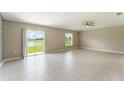 Spacious living room with tile floors, ceiling fan, and sliding glass doors with views of the pond at 3971 Guernsey Bnd, St Cloud, FL 34772