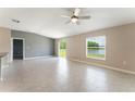 Open living area with tile floors, ceiling fan, and sliding glass doors with views of the pond at 3971 Guernsey Bnd, St Cloud, FL 34772