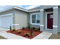 Charming home with fresh landscaping in front yard featuring mulch ground cover, decorative plants, and green grass at 475 Marion Oaks Mnr, Ocala, FL 34473