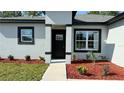 Well-manicured front yard with new landscaping and black trim on a modern gray home at 7382 Sw 129Th Ln, Ocala, FL 34473