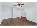 Cozy bedroom with light blue walls, wood-look floors, ceiling fan, closet, and an open door to the bathroom at 7998 Harbor Bend Cir, Orlando, FL 32822