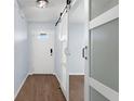 Welcoming entryway showcasing a white front door, wood-look flooring, and a stylish sliding barn door at 7998 Harbor Bend Cir, Orlando, FL 32822