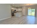 Bright, open-concept kitchen and living area with stainless steel appliances, white cabinets, and ample natural light at 851 Marion Oaks Mnr, Ocala, FL 34473
