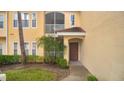 Inviting entrance to the home, featuring a screened patio, a well-manicured landscape, and a covered front door at 12220 Wild Iris Way # 103, Orlando, FL 32837