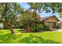 Inviting home exterior surrounded by flowering trees and lush landscaping, offering great curb appeal at 1247 Rosemary Dr, Orlando, FL 32807