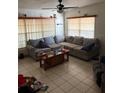 Cozy living room featuring a large sectional sofa, ceiling fan, and lots of natural light at 128 N Sunland Dr, Sanford, FL 32773