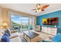 Stylish living room with a ceiling fan, balcony access, a blue accent wall, and comfortable neutral seating at 13427 Blue Heron Beach Dr # 306, Orlando, FL 32821