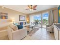 Bright living room featuring tile flooring, comfortable seating, and access to a balcony with great views at 13427 Blue Heron Beach Dr # 306, Orlando, FL 32821