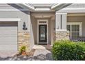 Close-up of front entrance with stone accents and decorative glass door at 1386 Longley Pl, Deland, FL 32724