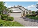 Inviting home with a brick-paved driveway, two-car garage, and professionally landscaped front yard at 1386 Longley Pl, Deland, FL 32724