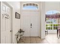 Bright entryway with tile flooring, featuring a white double door and decorative glass table at 140 Rangeline Woods Cv, Longwood, FL 32750