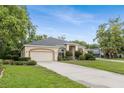 Wide shot showing this home's driveway, landscaping, and large garage that complements its neutral-toned stucco exterior at 140 Rangeline Woods Cv, Longwood, FL 32750