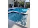 Inviting backyard with a refreshing pool, relaxing spa, and stylish screened enclosure at 1428 Casterton Cir, Davenport, FL 33897