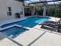 Relaxing backyard pool with a spa, screened enclosure and lounge chairs, perfect for outdoor entertainment at 1428 Casterton Cir, Davenport, FL 33897