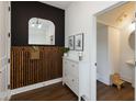 Stylish entryway with a black accent wall, vertical wooden slats, shoe storage, and a decorative arched mirror at 15408 Lebeau Loop, Winter Garden, FL 34787