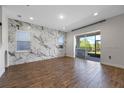 Spacious living area featuring tile flooring, a marble wall, and sliding glass doors at 15702 Vetta Dr, Bella Collina, FL 34756