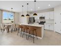 Modern kitchen features white cabinets, a large island with seating, and stainless steel appliances at 1773 Groveline Rd, St Cloud, FL 34771