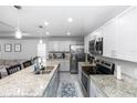 Open kitchen with granite countertops, stainless steel appliances, and ample cabinet space at 1857 E Cooper Dr, Deltona, FL 32725