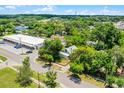 An aerial view showcases the property within a tree-filled neighborhood, with a red boundary line marking the property's limits at 201 W Washington St, Minneola, FL 34715