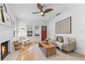 Bright living room with a decorative fireplace, ceiling fan, and hardwood floors at 205 W Princeton St, Orlando, FL 32804