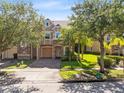 Charming two-story home featuring stone accents, a paved driveway, and lush landscaping at 2153 Cypress Villas Dr, Orlando, FL 32825