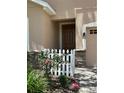 Close-up of the front door with a decorative picket fence and brick accents at 23820 Sardinia Dr, Sorrento, FL 32776