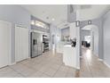 Open kitchen with stainless appliances, white cabinetry, and tiled floors at 2511 Brookstone Dr, Kissimmee, FL 34744