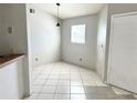 Bright dining area featuring neutral walls and tile floors, illuminated by a modern pendant light at 2524 Woodgate Blvd # 201, Orlando, FL 32822