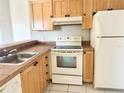 Efficient kitchen with wooden cabinets, white appliances, and tiled countertops, ready for cooking at 2524 Woodgate Blvd # 201, Orlando, FL 32822