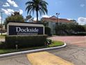 Dockside Condominiums signage is surrounded by manicured bushes and trees at 2524 Woodgate Blvd # 201, Orlando, FL 32822