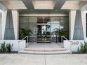 Elegant building entrance with floor-to-ceiling windows, manicured greenery, and a symmetrical design at 260 S Osceola Ave # 1207, Orlando, FL 32801