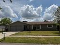 Charming single-story home featuring a well-maintained lawn and an attached two-car garage at 2747 Rose Moss Ln, Orlando, FL 32807