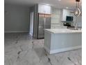 Modern kitchen with stainless steel appliances, white cabinets, and a center island with quartz countertops at 2747 Rose Moss Ln, Orlando, FL 32807