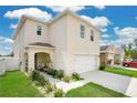 Two-story home with neutral siding, an attached garage and a covered porch with seating at 2834 Common Crane Ct, St Cloud, FL 34773