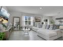 Bright living room featuring modern decor, a large sectional sofa and wood-look flooring at 2834 Common Crane Ct, St Cloud, FL 34773