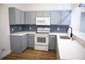 Updated kitchen features modern appliances, gray cabinets, white countertops and stylish backsplash at 30101 Pga Dr, Sorrento, FL 32776