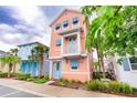 Quaint peach-colored two-story home featuring blue shutters and a small balcony, nestled among lush greenery at 3062 Pirate Way, Kissimmee, FL 34747