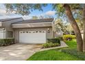 Charming gray townhome with tile roof, two-car garage, and well-maintained landscaping on a sunny day at 3987 Lancashire Ln # 3987, Longwood, FL 32779